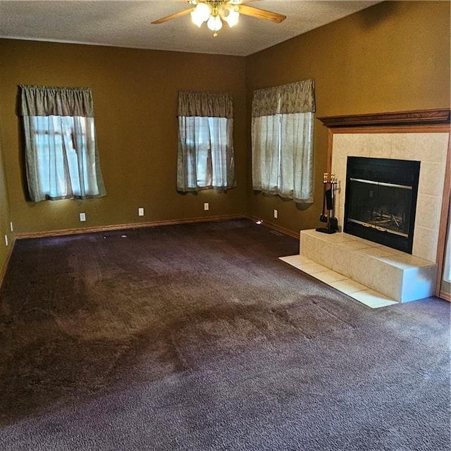 unfurnished living room with a tile fireplace, carpet, a textured ceiling, and ceiling fan