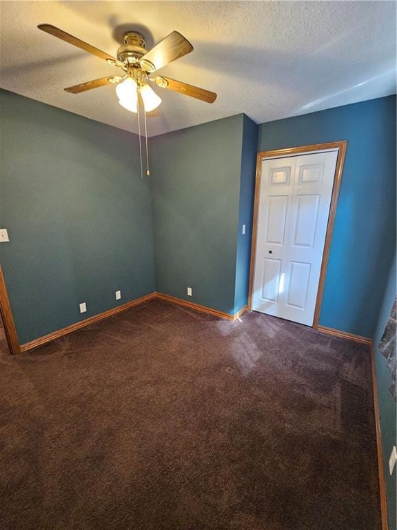 unfurnished bedroom with a textured ceiling, carpet flooring, ceiling fan, and a closet