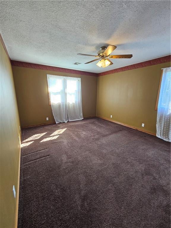 carpeted empty room with ceiling fan and a textured ceiling