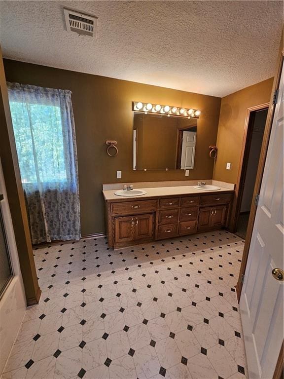 bathroom with a textured ceiling and vanity