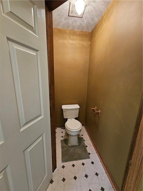 bathroom featuring a textured ceiling and toilet