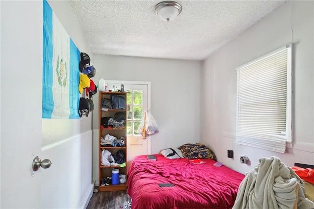 bedroom with a textured ceiling and hardwood / wood-style flooring