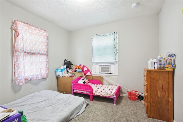 bedroom featuring cooling unit, a textured ceiling, and carpet flooring