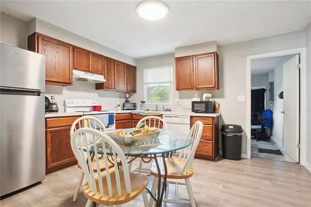 kitchen featuring light wood-type flooring, sink, and white appliances