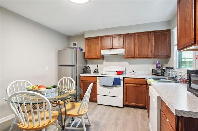 kitchen with white appliances, light hardwood / wood-style floors, and sink