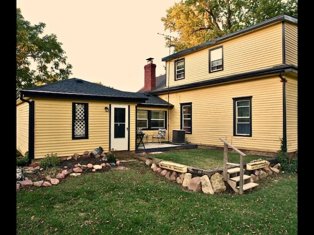 rear view of house with a lawn, a patio area, and central air condition unit