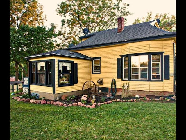 rear view of property featuring a yard