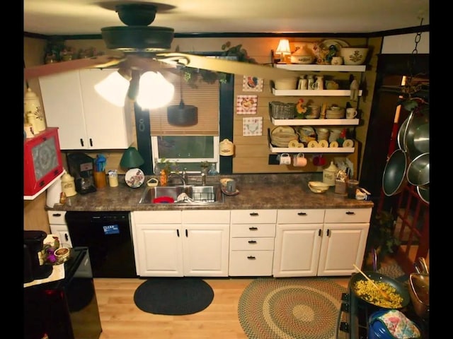 kitchen with ceiling fan, sink, white cabinetry, black dishwasher, and light wood-type flooring