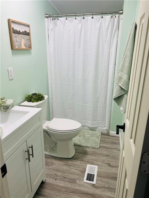 bathroom featuring wood-type flooring, a shower with curtain, vanity, and toilet