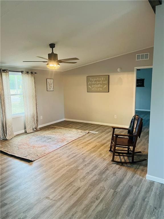 living area with wood-type flooring, vaulted ceiling, and ceiling fan