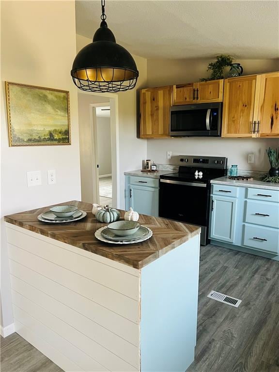 kitchen featuring dark hardwood / wood-style floors, white cabinetry, vaulted ceiling, stainless steel appliances, and decorative light fixtures