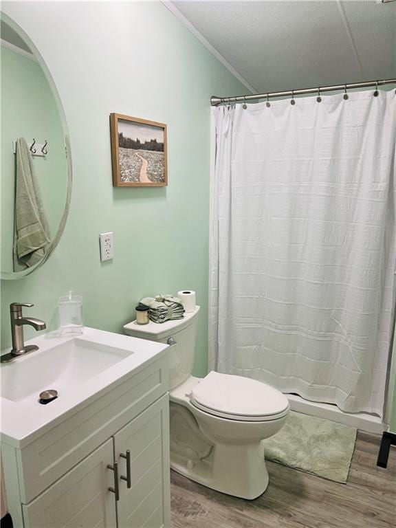 bathroom featuring wood-type flooring, toilet, ornamental molding, vanity, and curtained shower