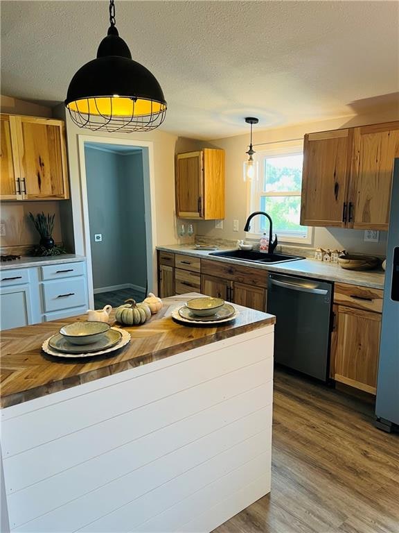 kitchen featuring appliances with stainless steel finishes, hanging light fixtures, and wooden counters