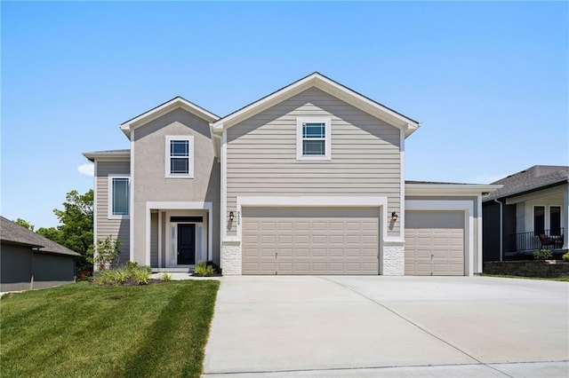 view of property featuring a garage and a front lawn