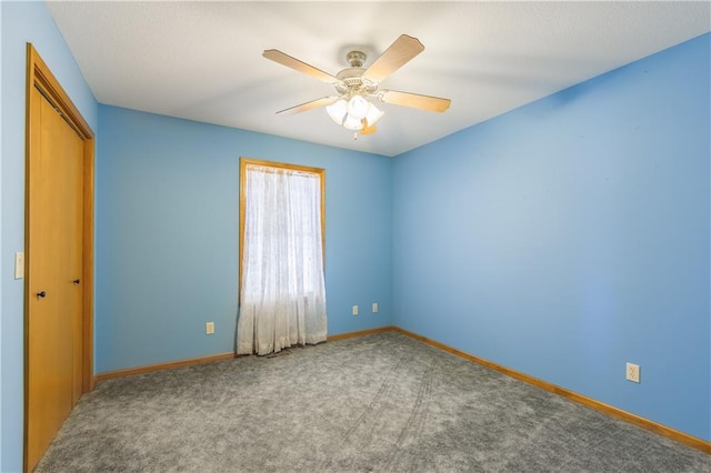 carpeted empty room featuring ceiling fan