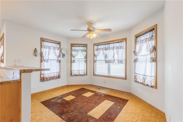 unfurnished dining area featuring ceiling fan