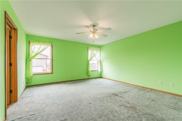 carpeted empty room with a healthy amount of sunlight and ceiling fan