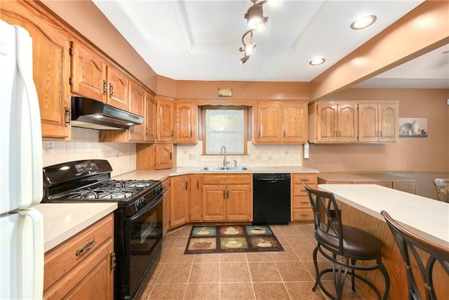 kitchen with tasteful backsplash, a kitchen bar, black appliances, sink, and tile patterned floors