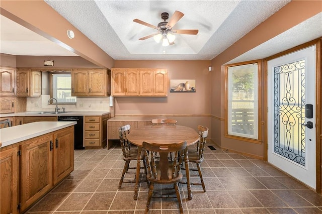 dining area with sink, dark tile patterned flooring, a textured ceiling, and ceiling fan