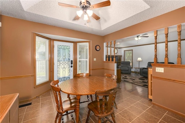 dining room with a textured ceiling, tile patterned floors, and ceiling fan