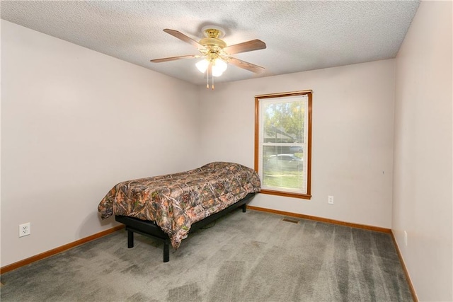 carpeted bedroom with a textured ceiling and ceiling fan