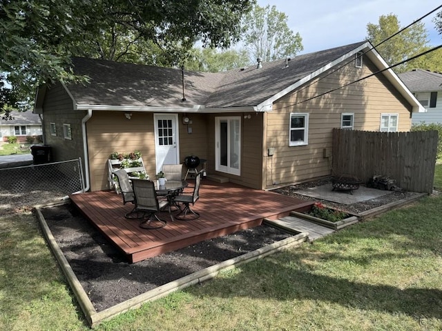 rear view of house featuring a deck and a lawn