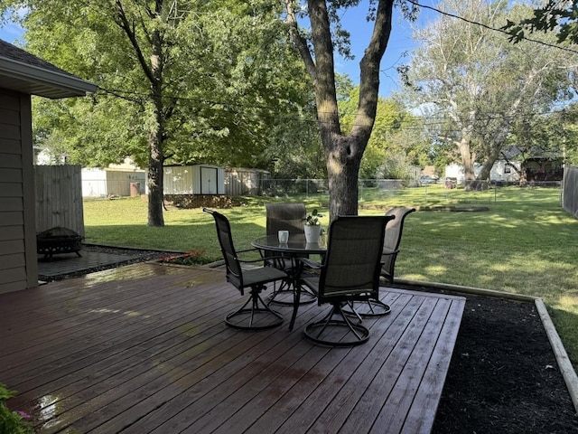 wooden terrace with a storage shed and a yard