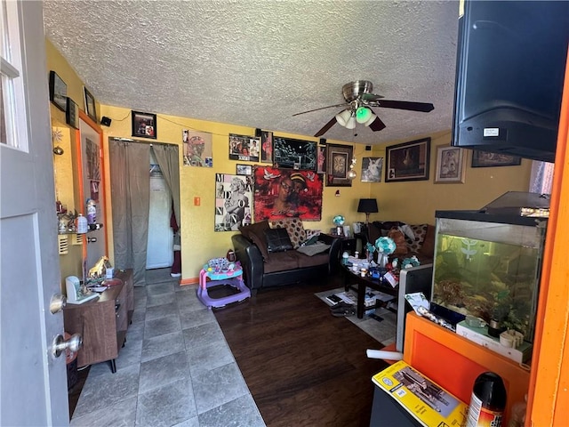 living room featuring ceiling fan, a textured ceiling, and dark hardwood / wood-style flooring