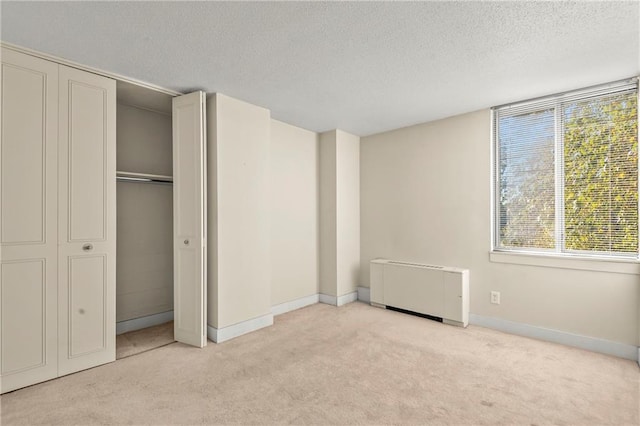 unfurnished bedroom with light carpet and a textured ceiling