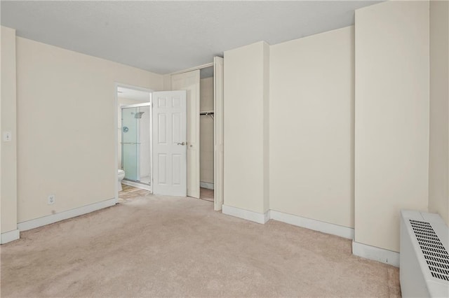 unfurnished bedroom with light carpet and ensuite bathroom