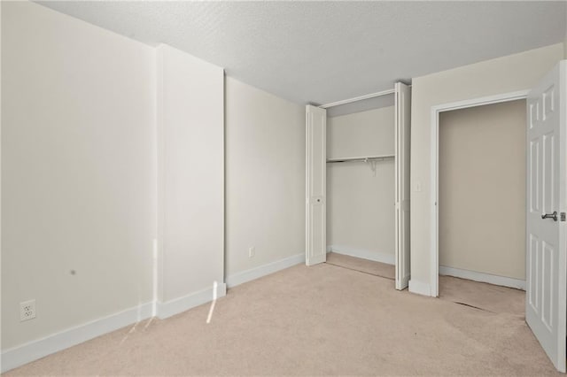 unfurnished bedroom featuring a textured ceiling and light carpet