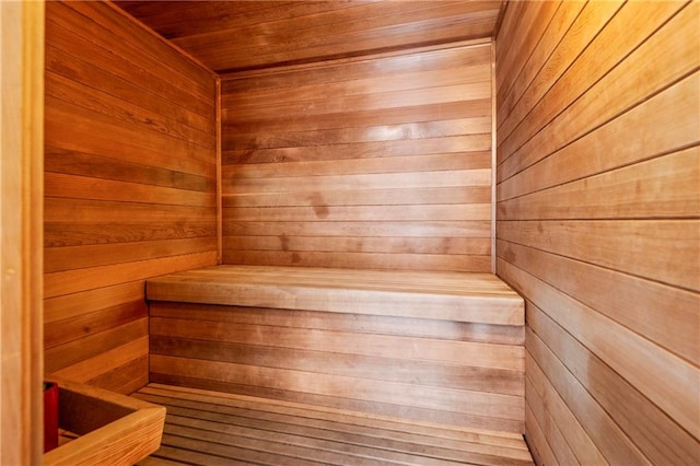 view of sauna featuring wood ceiling and wooden walls