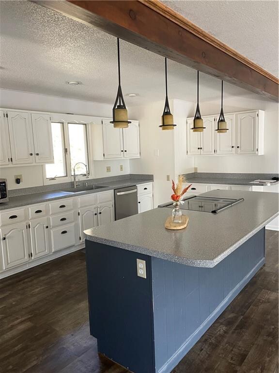 kitchen with stainless steel appliances, hanging light fixtures, white cabinets, and dark hardwood / wood-style flooring