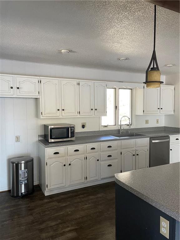 kitchen featuring appliances with stainless steel finishes, dark hardwood / wood-style floors, and white cabinets