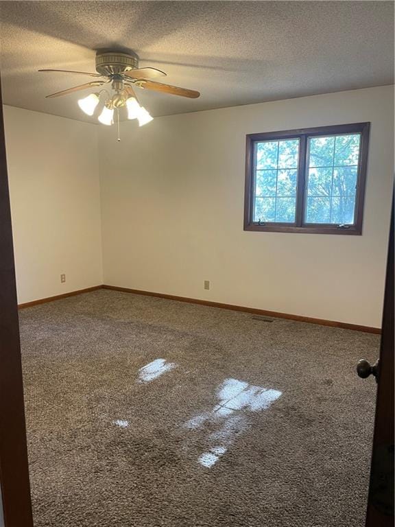 carpeted empty room featuring ceiling fan and a textured ceiling