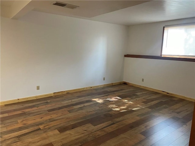 unfurnished room with dark wood-type flooring