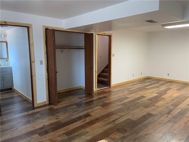 unfurnished bedroom with dark hardwood / wood-style floors and connected bathroom