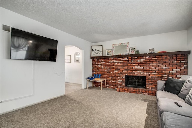 living room with a fireplace, carpet flooring, and a textured ceiling