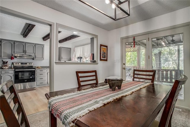 dining room with a textured ceiling and light hardwood / wood-style flooring