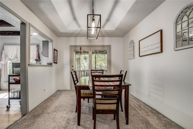 dining area featuring carpet flooring and a textured ceiling