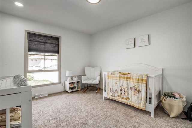 bedroom featuring a crib and carpet flooring