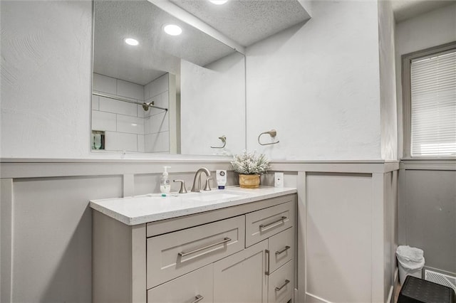 bathroom featuring a shower and vanity