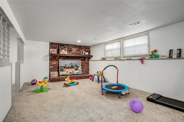 rec room with a fireplace, carpet, and a textured ceiling