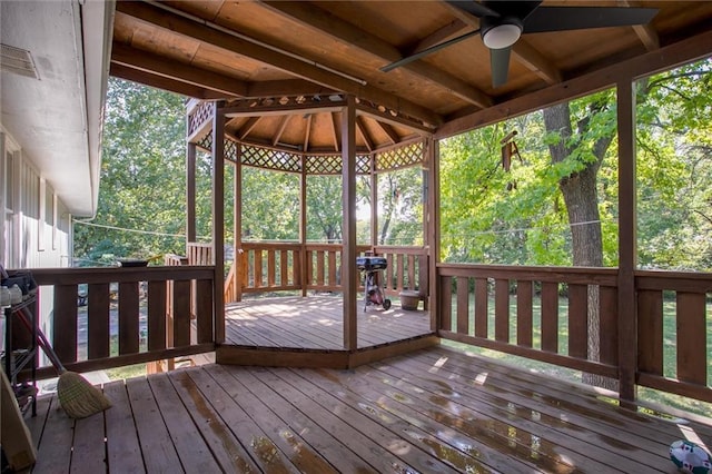 wooden deck with ceiling fan and a gazebo