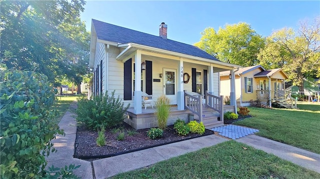 bungalow with a front lawn and covered porch