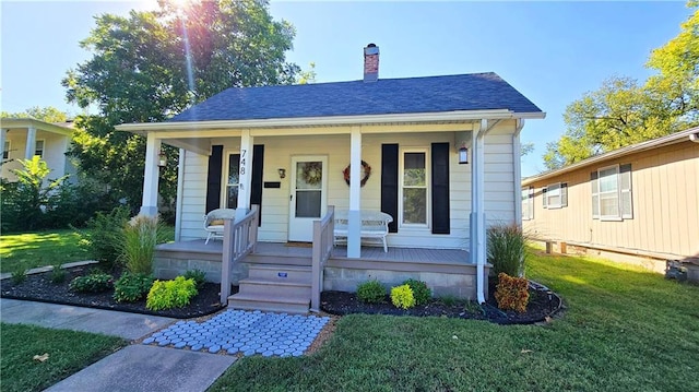 bungalow-style home with covered porch and a front yard