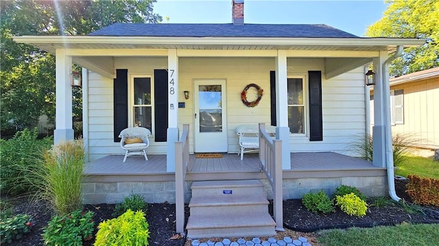 view of exterior entry featuring covered porch