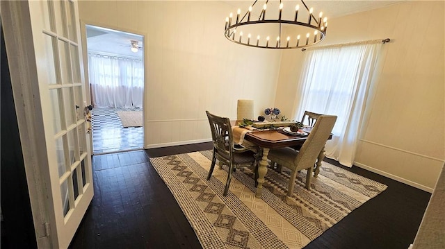 dining area featuring ornamental molding, a healthy amount of sunlight, dark wood-type flooring, and an inviting chandelier