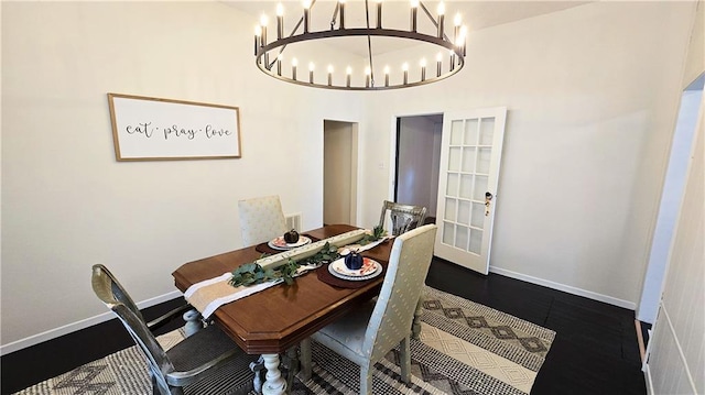 dining area with a towering ceiling and an inviting chandelier