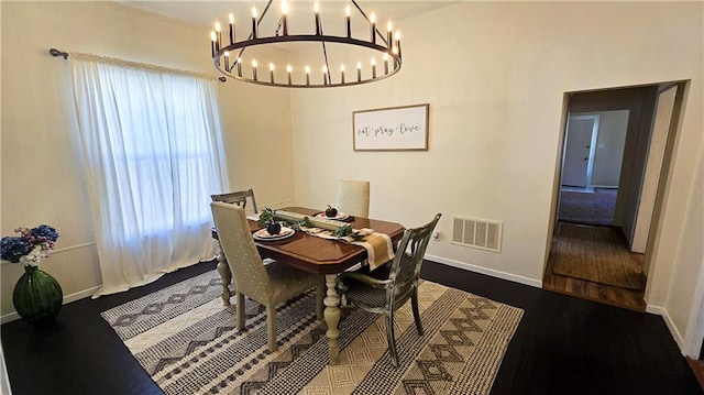 dining space featuring hardwood / wood-style flooring and a notable chandelier